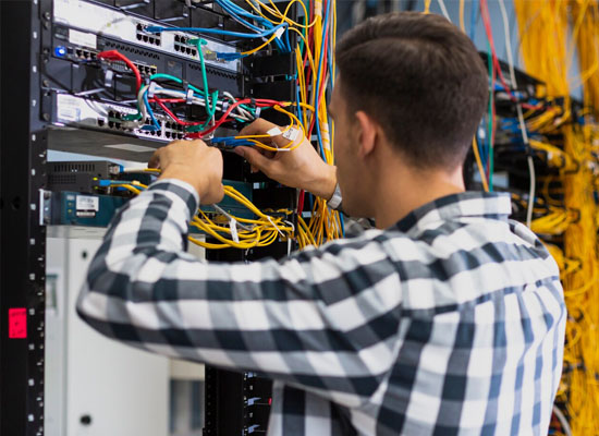Técnico ordenando cableado de red en rack